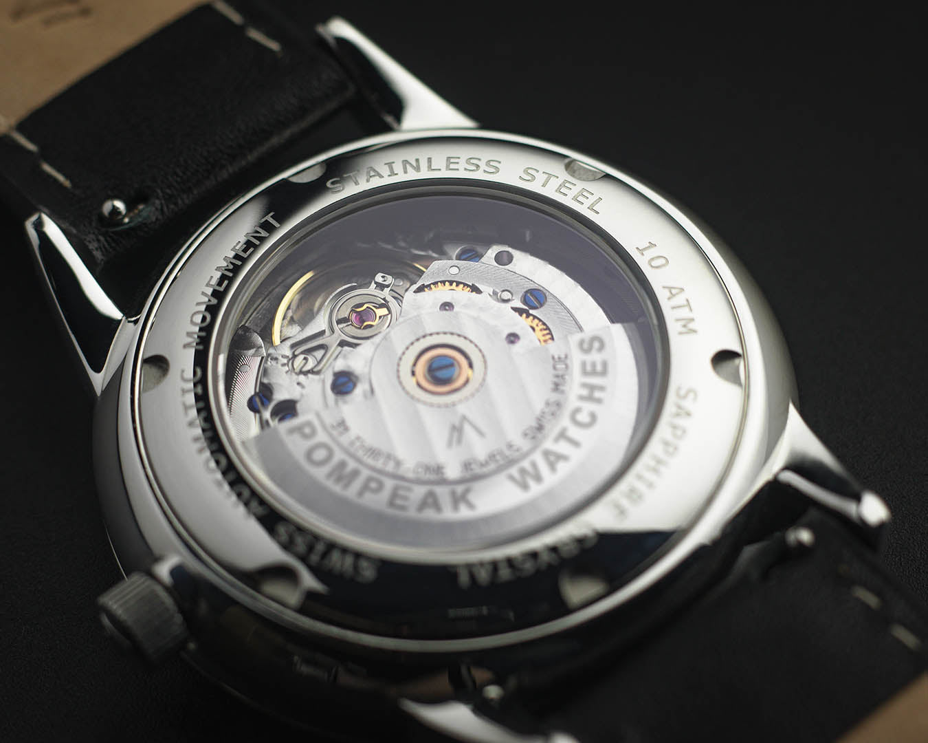 Mallory Timeless White watch caseback with a decorated movement, exhibition case, and quick-release leather strap for easy swapping.
