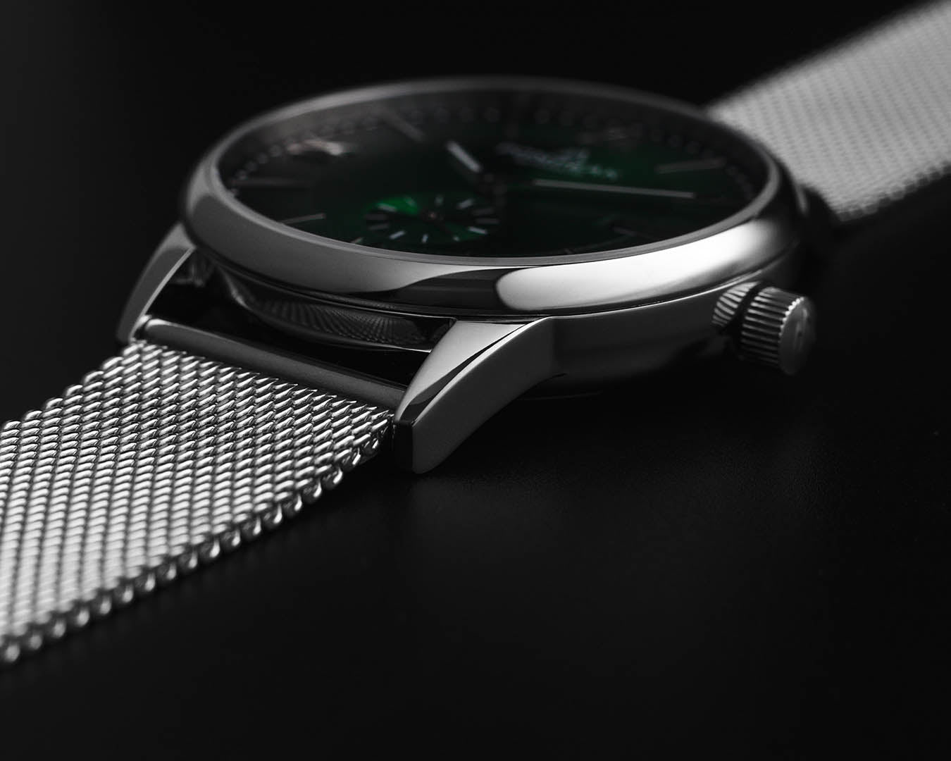 Close-up of the Mallory British Racing Green watch on a Milanese mesh strap, highlighting the polished case lugs and seamless integration.