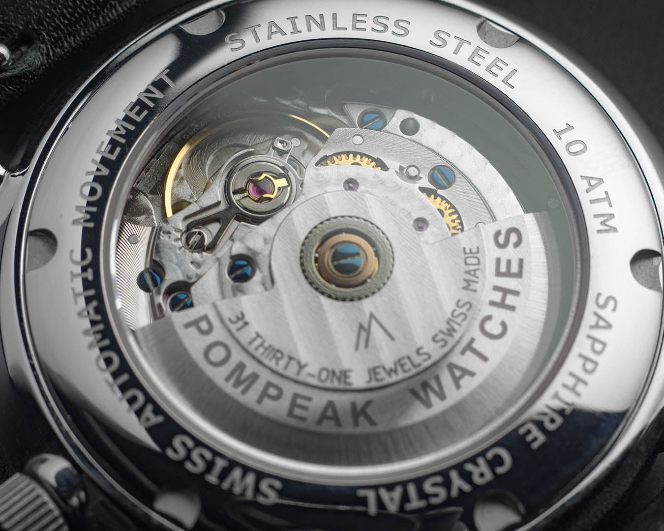 Close-up of the Swiss Sellita SW260-1 movement in the Mallory Timeless White watch, featuring rhodium plating, blued screws, and an engraved rotor.