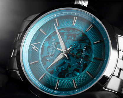 Close-up of a Pompaek Automatic watch featuring a vibrant translucent guilloche turquoise blue dial